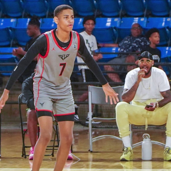 Class of 2025 recruit Kiyan Anthony pictured with his father, Carmelo Anthony, watching from the sideline.
